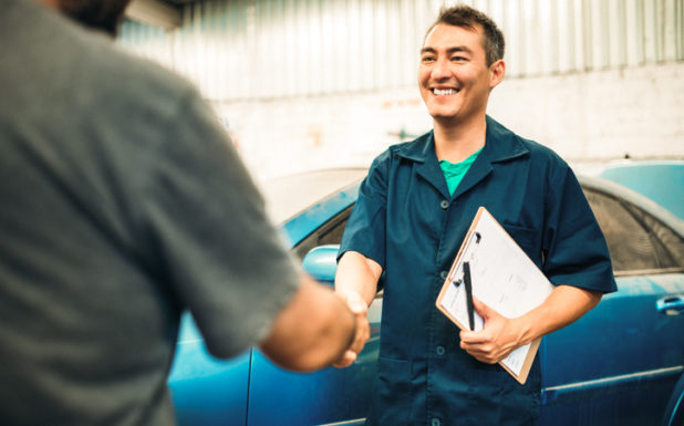 Trustworthy Care Photo Smiling mechanic shaking hands with a person.