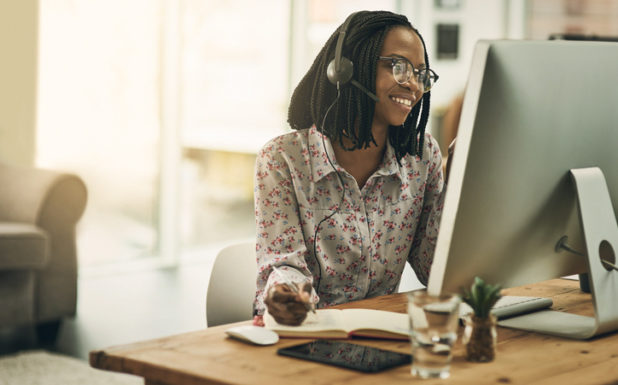 Plan Assistance Photo A woman wearing a headset while sitting at a computer.